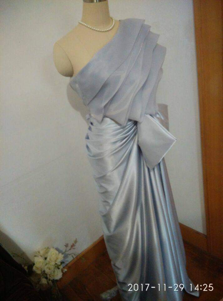 ชื่อสินค้า (TH): ชุดราตรีสีเทาเงินไหล่เดี่ยวแต่งโบว์หรู ชื่อสินค้า (EN): Silver One-Shoulder Evening Gown with Elegant Bow